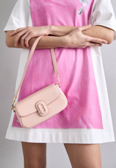 Sac à main en cuir rose clair avec rabat et fermeture logo proéminent. Anse réglable, texture lisse, forme rectangulaire, accents en métal doré.