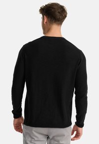 Zwarte lange mouwen shirt van een gestructureerde stof, met een eenvoudige ronde halslijn en een relaxte fit, van achteraf gezien.