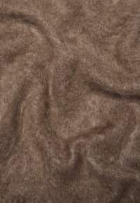 Zacht, bruin, pluizig gebreid stof met zichtbare, getextureerde vezels en zachte plooien die een warme, gezellige uitstraling creëren.