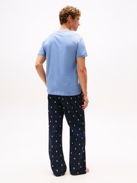 T-shirt in cotone azzurro chiaro a maniche corte abbinata a pantaloni della giacca blu scuro con un motivo di piccoli cerchi di vari colori.