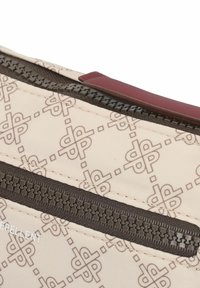 Beige gemusterte Stofftasche mit dunkelbraunen Reißverschlüssen und einem burgunderfarbenen Akzent. Verfügt über wasserabweisendes Material und ein umrandetes Logodesign.