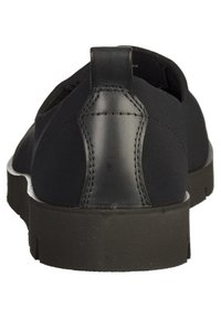 Chaussure noire avec une tige en tissu lisse et un talon en cuir noir texturé. Dotée d'une semelle en caoutchouc noire solide avec un profil bas.