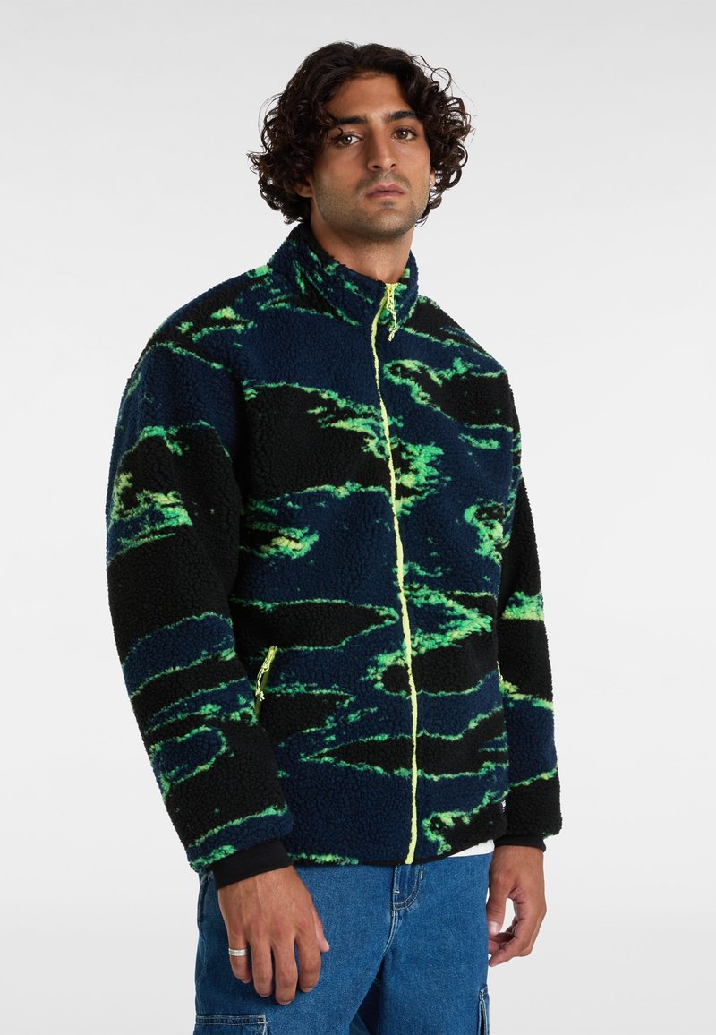 Fleecejack in zwart met groene en blauwe abstracte patronen, voorzien van een hoge kraag, voorkant met rits en elastische manchetten.