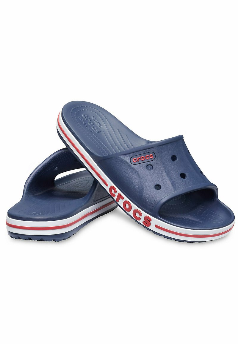 Sandales en caoutchouc bleu marine avec un design perforé, une semelle intérieure rembourrée et une semelle rayée blanche et rouge avec le logo "crocs".