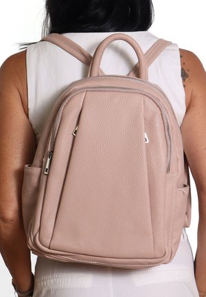 Sac à dos en cuir texturé rose avec double fermeture éclair, anse supérieure et bretelles réglables. Présente des poches latérales et une forme structurée.