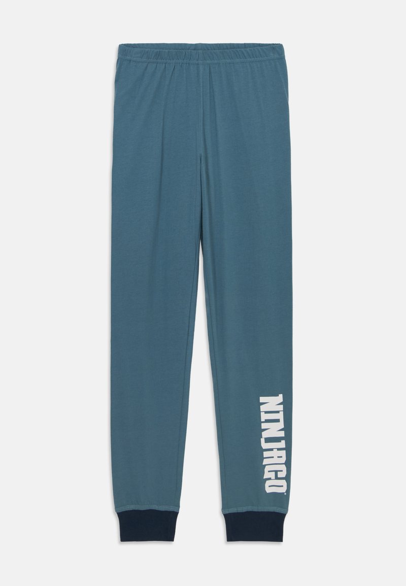 Niebieskie bawełniane spodnie dresowe z elastycznym paskiem w talii, zwężanymi nogawkami i napisem „NINJAGO” wydrukowanym na białej tkaninie na lewej nogawce. Ribbed ciemne mankiety.