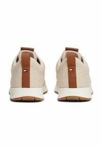 Sneakers a rete beige con un cappio brown; presentano una superficie testurizzata e una suola bianca con battistrada in gomma leggera. Logo del marchio sul tallone.