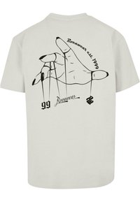 Hele halli T-särgi esiküljel on must graafiline tõmmis käest, millel on nöörid. Tekst sisaldab "Rocawear asutatud 1999" ja "99" koos stiilse "R"-ga.