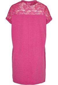 Roze top met korte mouwen, voorzien van een kanten achterpaneel, zachte stof en een relaxte pasvorm, met zijsplitten voor extra comfort en stijl.
