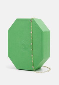 Green octagonal jewelry box made of textured material, featuring a gold chain with alternating crystal accents.
