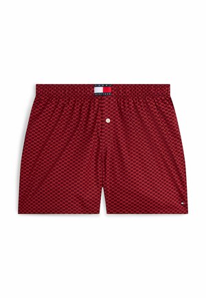 Boxer shorts rojos con un patrón geométrico, cinturilla elástica, cierre de botón y etiqueta de marca en la cintura. Textura de tela suave.