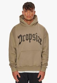 Hoodie in Hellbraun, mit einer Vorderseite Tasche und großem schwarzen Text "Dropsize." Weiches Material mit gerippten Bündchen und Saum.