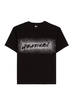 T-shirt en coton noir avec un graphique à pois blancs portant le texte "LA ZOOLOGIE" dans une police stylisée au centre. Manches courtes.