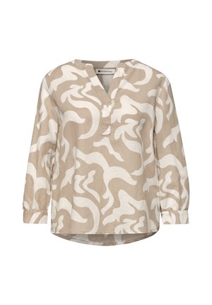 Blouse beige à manches longues avec motif abstrait blanc tourbillonnant, encolure en V et poignets élastiques.