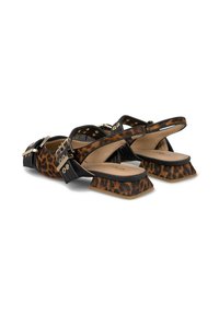 Sandalias de tacón bloque en negro y estampado de leopardo con una correa de tobillo asegurada, detalles de hardware dorado y cuero texturizado.