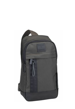 Grauer Rucksack aus strapazierfähigem Stoff mit strukturierter Oberfläche, ausgestattet mit einer vorderen Reißverschlusstasche und einem oberen Griff für einfaches Tragen.