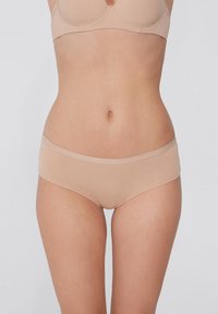Beige bezešvé boxerkové kalhotky vyrobené z jemné, hladké látky. Nízký pas s pružným páskem a bez viditelných švů pro elegantní střih.