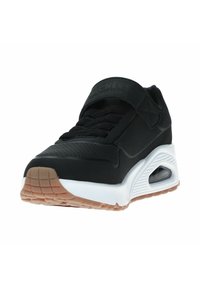 Zapatilla atlética negra con una superficie texturada, diseño con cordones, lengüeta acolchada y una entresuela blanca. Presenta una suela de goma con patrones de agarre.