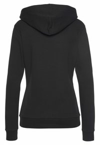 Sudadera negra con una textura suave, mangas largas y un diseño ajustado. Cuenta con capucha y puños y dobladillo acanalados. Sin logotipos ni patrones visibles.