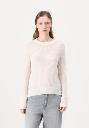 Light beige ribbed sweater with long sleeves and a crew neck, featuring a textured fabric and a slightly longer hem at the back.