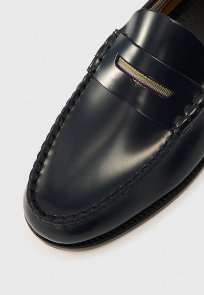 Marineblauwe leren loafers met een gladde afwerking, voorzien van een gestikte rand en een decoratieve uitsparing met een kleurrijk accent.