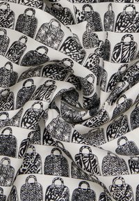 Tissu à motifs présentant des illustrations en noir et blanc de sacs à main avec des textures et des designs variés sur un fond clair.