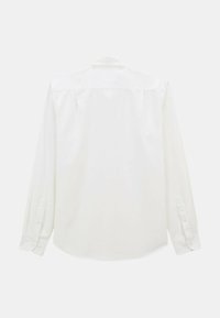 Chemise blanche à manches longues en tissu lisse. Elle possède un col classique, des poignets boutonnés et un dos droit sans motifs visibles.