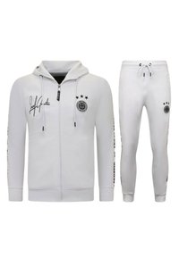 Witte atletische trainingsset met een rits-hoodie en taps toelopende broek, beide met zwarte logok accents en twee sterren op de mouwen.