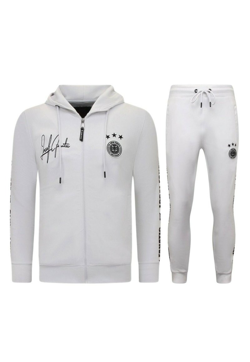 Witte atletische trainingsset met een rits-hoodie en taps toelopende broek, beide met zwarte logok accents en twee sterren op de mouwen.