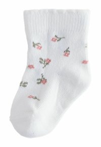 Baltas medvilninis kojinė su dygsniuota tekstūra, visame paviršiuje išmargintas mažais rožiniais ir žaliais gėlių raštais. Pažasties aukščio dizainas su elastingu rankogaliu.