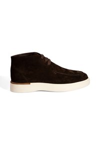 Donkerbruine suede enkelboot met een witte rubberen zool en gestreepte bruine veters, weergegeven in zijprofiel op een witte achtergrond.