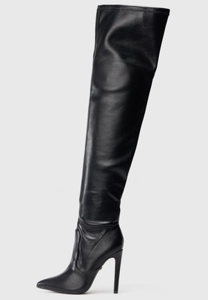 Melna ādas augstajā ceļa zābaks ar smailu purngalu un augstu stiletto papēdi. Gluda tekstūra un pieguļošs dizains, kurā ir minimāla aparatūra.