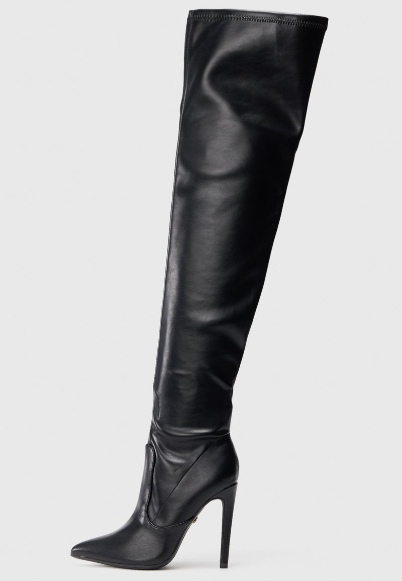 Fekete bőr, combfőig érő csizma hegyes orral és magas, tűs sarokkal. Simább textúrájú és testhezálló kialakítás, minimális hardverrel.