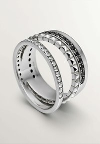 Anillo de plata compuesto por dos bandas, una con piedras transparentes y la otra con acentos negros, con patrones geométricos y un acabado pulido.