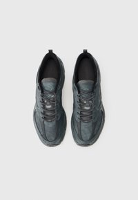 Pantofi sport de culoare gri închis, cu o suprafață texturată, vârf rotund, sistem de șireturi în față și guler căptușit pentru confort și susținere.