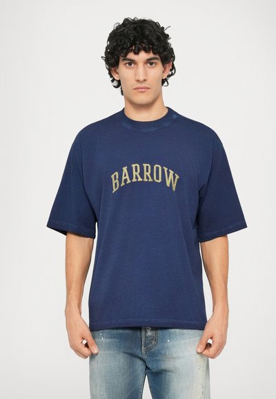 Navy blue oversized t-skjorte laget av bomull, med korte ermer og rund hals. "BARROW" er trykt i en buet, kontrasterende farge over brystet.