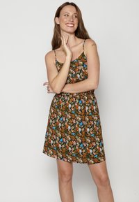Vestido floral con fondo negro. Presenta tirantes finos, una cintura ajustada y una falda relajada. Patrón colorido de flores y hojas.