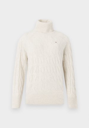 Kremfarget kabelstrikket turtleneck genser med lange ermer og ribbestrikkede mansjetter og kant, med en liten brodert logo på brystet.