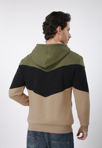Φούτερ με κουκούλα σε σχεδιασμό με μπλοκ χρωμάτων σε ελιά, μαύρο και μπεζ, με υφασμάτινη υφή και ριμπ μανσέτες.