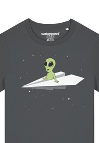 Grijze t-shirt met een groene alienfiguur op een wit papieren vliegtuig, met sterren op de achtergrond. Ronde hals en casual pasvorm.