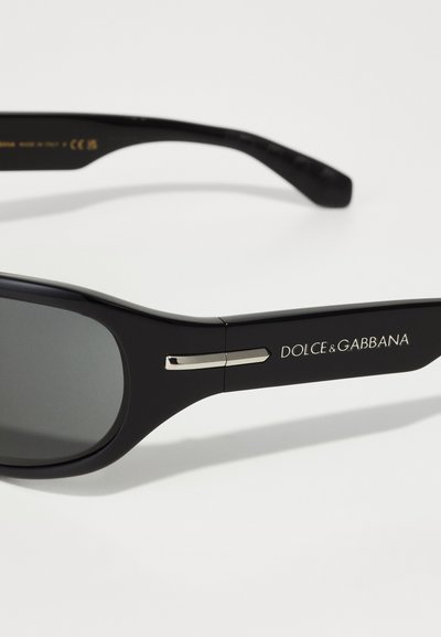Mustad prillid hallide läätsede ja plastraamidega, millel on metallist aktsendid. Ühel küljel on logo "DOLCE & GABBANA".