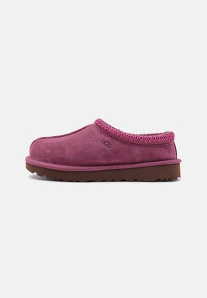 Chaussure en daim violette à enfiler avec semelle marron et bord cousu, marquée d'un petit logo en relief sur le côté.