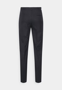 Pantaloni neri su misura, slim fit, realizzati in tessuto morbido. Presentano una singola tasca posteriore con cuciture raffinate e un passante per la cintura.