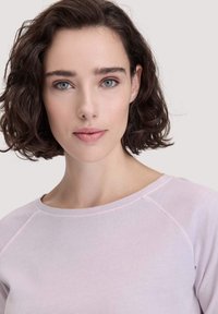 Hellrosa Baumwoll-Sweatshirt mit Rundhalsausschnitt und Raglanärmel. Glatte Textur, minimalistisches Design, ohne zusätzliche Muster oder Hardware.