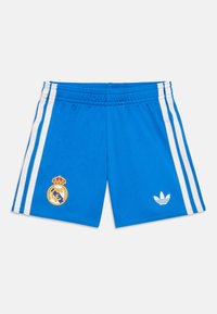 Blauwe sportshorts met witte zijkanten, Real Madrid-embleem op het linkerpootje, en Adidas-logo op het rechterpootje tegen een witte achtergrond.