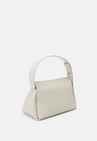 Borsa a mano in pelle beige con una forma strutturata, base piatta e una tracolla larga e regolabile. Texture liscia e design minimalista.