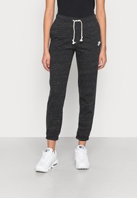 Svarta sweatpants med texturerad yta, elastisk midja med dragsko och sidofickor. Nike-logga vid höften.