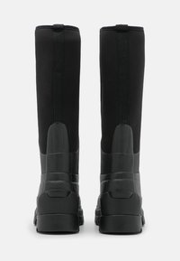 Mustat vedenpitävät saappaat, joissa on korkea, sileä neopreenivarsi ja teksturoitu kumikoristelu, ja joissa on kestävä musta pohja ja vahvistettu kanta.