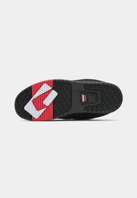 Talpa de teniși negri cu o suprafață texturată pentru aderență, accent din cauciuc roșu cu un logo alb și zonă întărită pentru călcâi cu un model hexagonal.