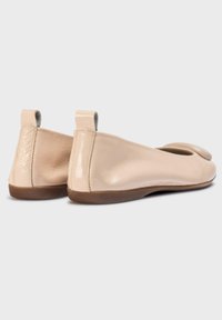 Ballerine in pelle beige con finitura liscia, punta arrotondata e piccola linguetta sul retro. Progettate con suola in gomma flessibile.